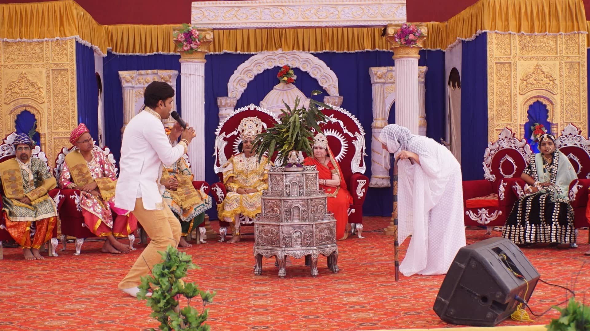 Celebration stage with silver samavasaran and devotees in traditional dress